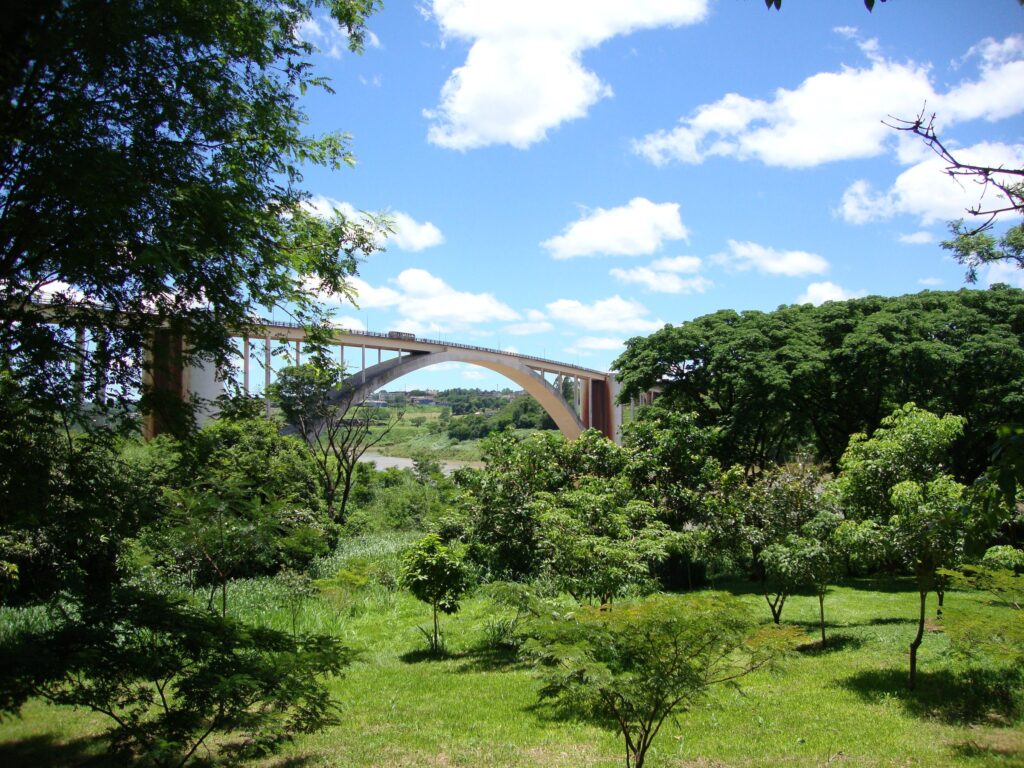 Arco del Puente de la Amistad sobre el río Paraná entre vegetación, en Ciudad del Este